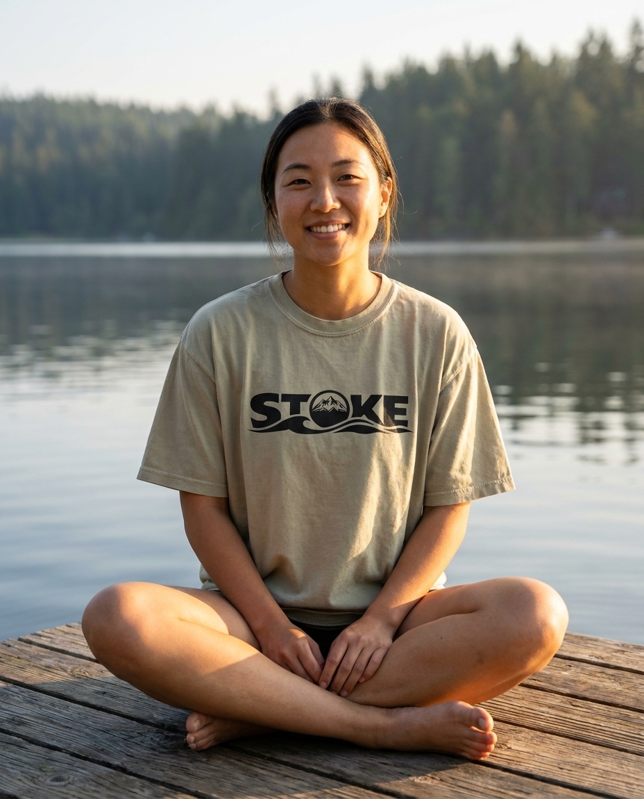 Woman on a lake dock at sunrise in the unisex STOKE Heavyweight Trail Tee in Faded Eucalyptus